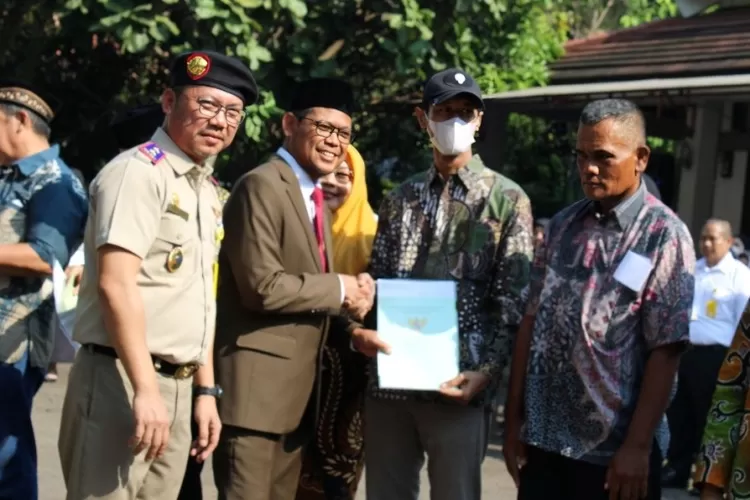 Kepala BPN Kota Depok Indra Gunawan bersama Wakil Wali Kota Depok Imam Budi Hartono menyerahkan sertifikat PTSL kepada warga perwakilan Pemkot Depok dan PUPR di sela-sela upacara dan peringatan Hantaru 2023, di halaman parkir Kantor Pertanahan Kota Depok, Senin 25 September 2023 (SUGAWA/Janter)