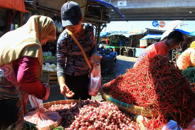 Dua orang ibu sedang memilih bawang yang ingin dibelinya di Pasar Kemiri, Kota Depok (janter)